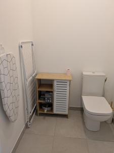 a bathroom with a toilet and a wooden cabinet at Ti Malo - Appartement proche plage Dunkerque in Dunkerque +17 photos
