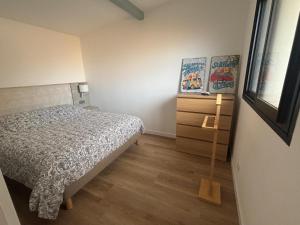 ein kleines Schlafzimmer mit einem Bett und einer Kommode in der Unterkunft DACSE-VILLAGE - Gite 02 in Dax