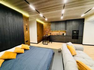 a bedroom with a bed and a couch and a kitchen at New Premium LOFT studio in Zhytomyr +9 photos