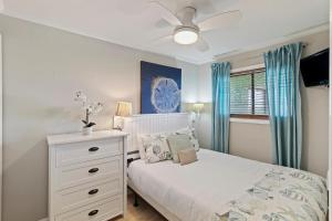a bedroom with a white bed and a ceiling fan at SC206A: 206A Sea Cabin in Isle of Palms +29 photos