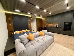 a living room with a couch with yellow pillows at New Premium LOFT studio in Zhytomyr