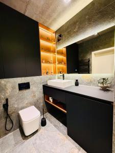 a bathroom with a white toilet and a sink at New Premium LOFT studio in Zhytomyr