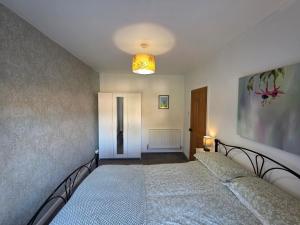 - une chambre avec 2 lits et un éclairage dans l'établissement Cosy Apartment in Fettercairn, à Fettercairn