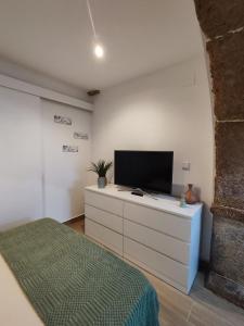una camera da letto con un letto e una TV a schermo piatto di Templar Arch Retreat a Tomar