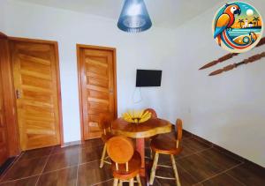 ein Esszimmer mit einem Holztisch und Stühlen in der Unterkunft Casas Araras de Corumbau, Piscina, a 5 Min da Praia in Corumbau