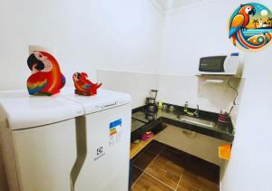 eine kleine Küche mit Spüle und Kühlschrank in der Unterkunft Casas Araras de Corumbau, Piscina, a 5 Min da Praia in Corumbau