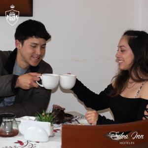 a man and woman sitting at a table drinking coffee at Hoteles Silva Inn in Cajamarca