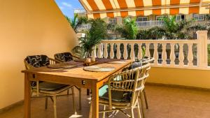 a wooden table and chairs on a balcony at Primavera apartment with heated pool in Palm-Mar