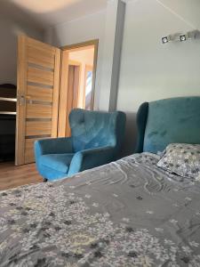 a bedroom with a blue chair and a bed at Angela 的度假别墅 in Sękocin Stary +7 photos