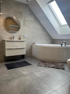 a bathroom with a tub and a sink and a mirror at Angela 的度假别墅 in Sękocin Stary