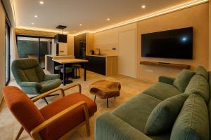 a living room with a couch and a flat screen tv at L'orée du bois - Contis - Ocean and Spa in Saint-Julien-en-Born