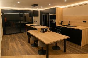 a kitchen with a wooden table and a counter top at L'orée du bois - Contis - Ocean and Spa in Saint-Julien-en-Born
