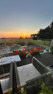 a sunset over a patio with a table and flowers at Ölschnitzer Loft in Lampertswalde