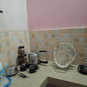 a kitchen counter with a stove with pots and pans at Atithi Homestay in Sivasagar