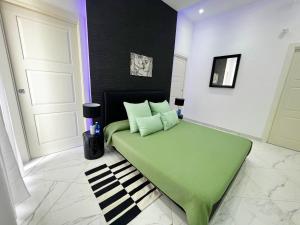 a bedroom with a green bed in a room at Veneto White Suite in Torre del Greco