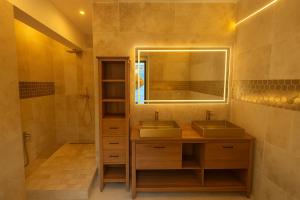 a bathroom with two sinks and a mirror at L'orée du bois - Contis - Ocean and Spa in Saint-Julien-en-Born +17 photos