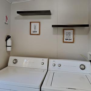 a laundry room with two white washes and two pictures at Island Club #21 in Put-in-Bay