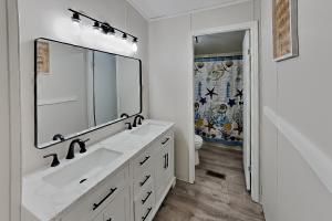 a white bathroom with a sink and a mirror at Island Club #21 in Put-in-Bay