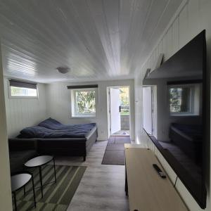 a bedroom with a bed and a couch and a table at Just Sleep Arendal in Arendal