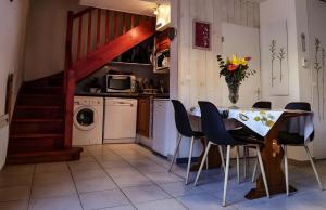 a kitchen with a table and chairs and a kitchen with a staircase at Gite Clarabide in Loudenvielle
