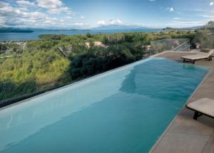 an infinity pool with a view of the water at Casa Veronica in Manerba del Garda
