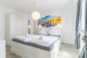 a white bedroom with a white bed and a painting at Bodensee Gateway - Stockach in Stockach