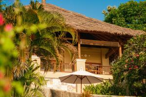 una casa con una sombrilla delante de ella en Aquamarine Seaview Villa, en Amed