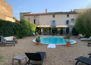 a courtyard with a swimming pool in front of a building at Aux Anges Gardiens in Carcassonne