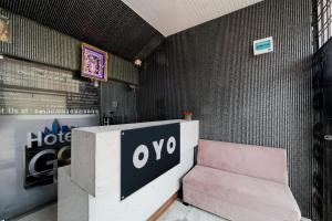 a pink bench next to a wall with a sign at Hotel O G9 in Akolia