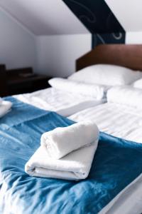 two white towels sitting on top of a bed at GAJOVA Restauracja & Nocleg in Pobiedziska