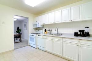 a kitchen with white cabinets and a sink at Well-Equipped Apartment Close to Metro Station in Addison Heights