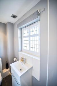 CockenzieにあるModern 4-Bed Home, Tranentの洗面台と窓のある白いバスルーム +28枚の写真