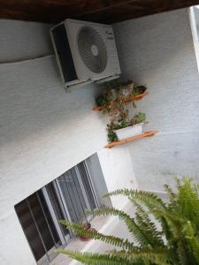a fan on the side of a building with plants at Aila Apartament in Gjirokastër