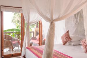 Un dormitorio con una cama con dosel y un balcón. en Aquamarine Seaview Villa, en Amed 75 fotos más