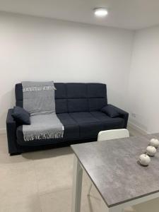 a living room with a black couch and a table at Grand studio climatisée in Blanzy