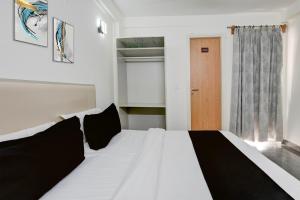 a white bed with black pillows in a room at Hotel O Kalka in Indraprast +75 photos