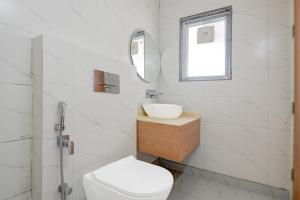 a white bathroom with a sink and a toilet at Hotel O Kalka in Indraprast