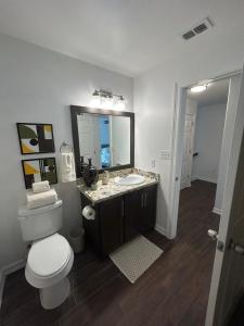 Un baño con inodoro, lavabo y espejo. en Fully Furnished 2 bedroom, en Brownsville