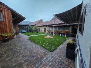 Un patio trasero con un patio de ladrillo y un jardín. en Feriencamp Familie Lange - Primc, en Radensdorf