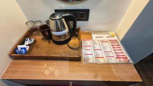 a coffeemaker on a wooden table with a coffee maker at Hotel Padma Krishna in Pune