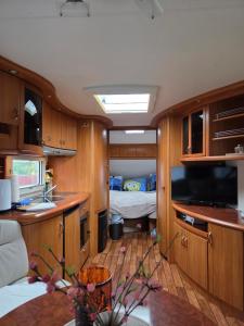 Una cocina con fregadero y una cama en una habitación. en Feriencamp Familie Lange - Primc, en Radensdorf