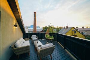 a balcony with wicker chairs and a table and chairs at Svaja ApartHotel in Šiauliai