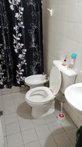 a bathroom with a toilet and a black and white shower curtain at Casa Rawson in San Rafael