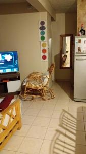 a living room with a tv and a chair and a refrigerator at Casa Rawson in San Rafael