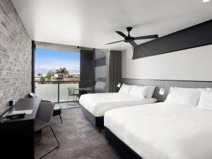 レッドクリフにあるThe Sebel Brisbane Margate Beachのベッド2台とバルコニー付きのホテルの部屋 +73枚の写真