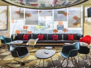 a lobby with a black couch and chairs at Ibis Mazatlan Marina in Mazatlán