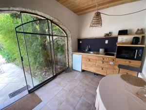 a kitchen with a large glass door and a table at Le Patio aux Oiseaux in La Ciotat