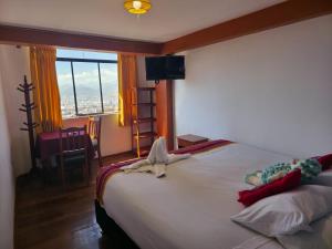 クスコにあるMirador All Sur Hostelの窓のある大きな白いベッドのある寝室