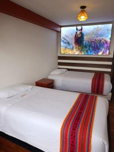 クスコにあるMirador All Sur Hostelのベッド2台 ホテルルーム 壁掛けテレビ付