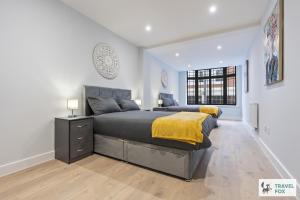 a bedroom with a large bed with a yellow blanket at Blair's Central Stay in Nottingham